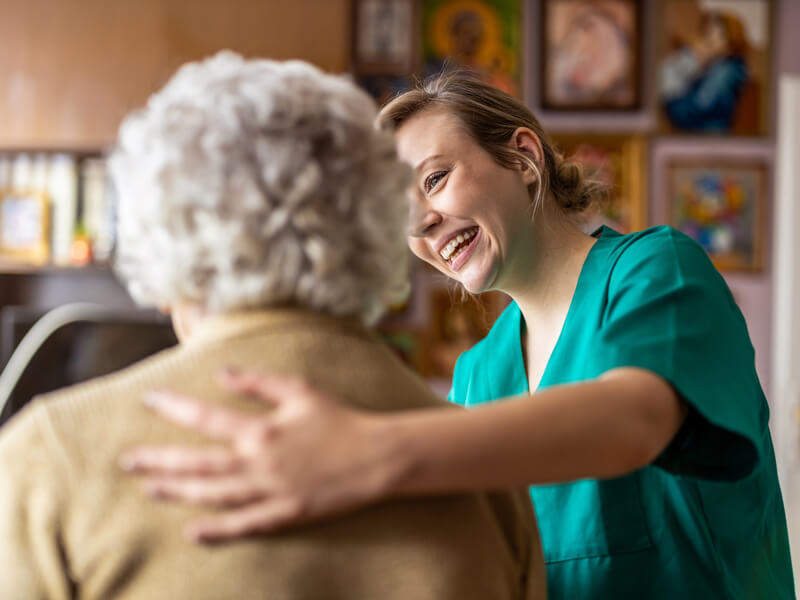 assisted living nurse helping elderly woman