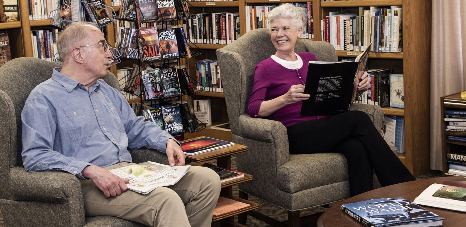 man and woman sitting in comfy chairs reading