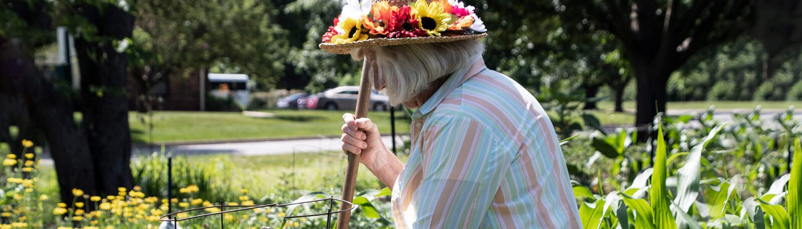 woman gardening wearing a flower hat