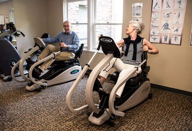 elderly couple on exercise bikes in gym